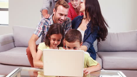 Familia-Sonriente-De-Varias-Generaciones-Usando-Una-Computadora-Portátil