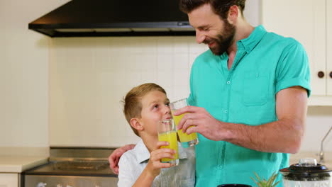Father-clink-orange-juice-glasses-with-his-son