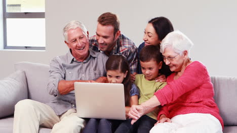 Familia-Sonriente-De-Varias-Generaciones-Usando-Una-Computadora-Portátil