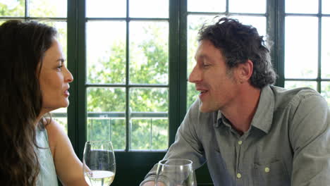 Cute-couple-having-lunch-and-toasting-with-wine