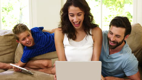 Familia-Sonriente-Mirando-Su-Computadora-Portátil