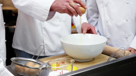 Chef-cracking-an-egg-into-a-bowl