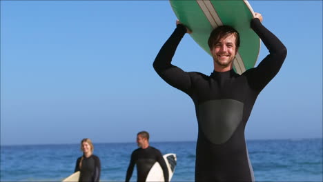 Friends-in-wet-suit-holding-surfboard