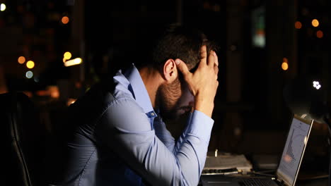 Tired-businessman-using-laptop-at-night