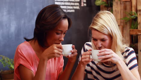 Friends-drinking-coffee-and-looking-at-smartphone