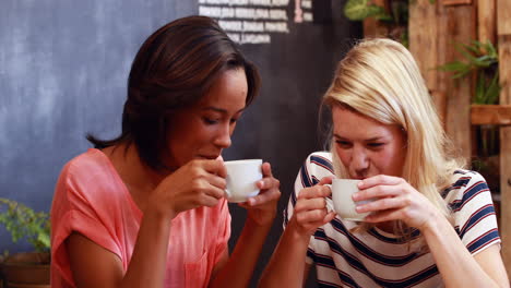 Amigos-Tomando-Café-Y-Mirando-El-Teléfono-Inteligente