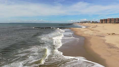 An-aerial-view-of-waves-crashing-against-the-beach-in-slow-motion