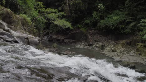 Water-gently-cascading-over-the-rocks-of-Goa-Rang-Reng-Waterfall-in-Bali,-captured-in-a-static-slow-motion-shot