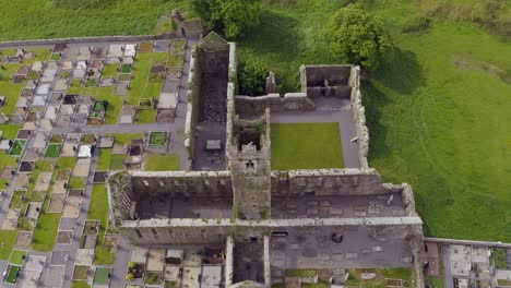 Claregalway-Friary-tower-at-center-of-historic-ruins-drone-rises-to-top-down-bird's-eye-view