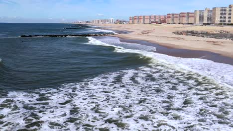 Una-Vista-Aérea-De-Las-Olas-Rompiendo-En-La-Playa-En-Cámara-Lenta