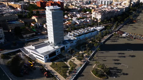 Tall-resort-hotel-building-and-panoramic-of-Estepona,-aerial-drone-view