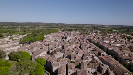 High-aerial-orbiting-shot-of-downtown-Pezenas-with-an-antique-church