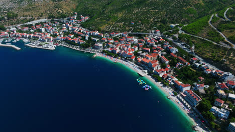 Vista-Aérea-Que-Rodea-La-Ciudad-De-Podgora,-En-La-Soleada-Riviera-De-Makarska,-Croacia.