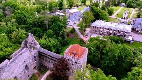 Aerial-Drone-Reveals-medieval-castle-in-Latvian-green-urban-landscape-Riga-City-Castle-Of-The-Livonian-Order-In-Sigulda