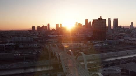 Toma-Panorámica-Aérea-De-Retroceso-Inverso-Del-Puente-De-La-Calle-Sexta-Y-El-Viaducto-En-Los-Ángeles,-California-Al-Atardecer