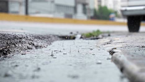 Drops-rain-on-puddle-surface.-Ground-level-and-slow-motion