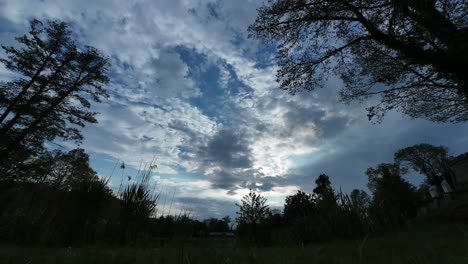 Timelapse-of-tranquil-landscape-under-a-fast-moving-dramatic-dusk-sky,-transitioning-from-day-to-night