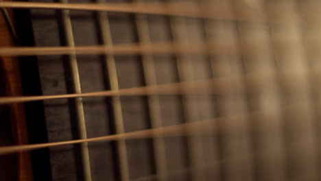 Extreme-closeup-on-acoustic-guitar-fretboard-as-string-virbate-as-they-are-picked