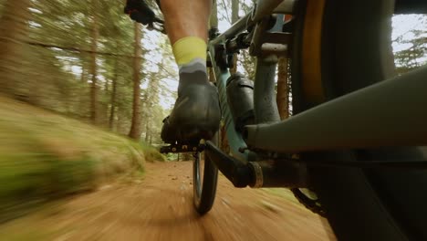 Camera-focusing-on-the-pedals-of-a-cyclist-mountain-biking-fast