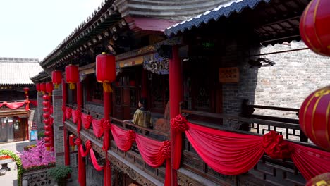 Qing-girl-walking-down-hallway-of-Chinese-house-with-red-lanterns