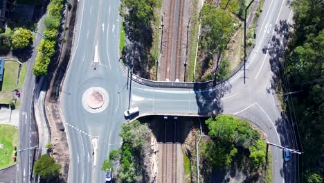 Querformatansicht-Von-Autos,-Die-über-Eine-Eisenbahnbrücke-Fahren,-Kreisverkehr,-Hauptstraße,-Verkehrsinfrastruktur,-Transport,-Ourimbah,-Central-Coast,-Australien,-Drohnenluftaufnahme