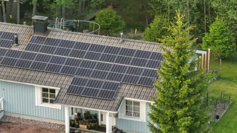 Solar-powered,-countryside-house,-on-a-summer-day---crop-lens-drone-shot