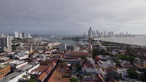 Cartagena's-historic-center-and-modern-skyline-with-coastal-backdrop,-aerial-view