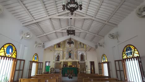 Church-of-Minca-with-ornate-chandeliers-and-white-wooden-beams-on-the-ceiling