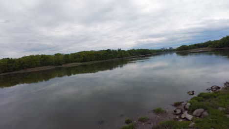 Eine-FPV-Drohnenansicht-Aus-Geringer-Höhe-über-Einem-Flachen-See-Mit-Reflektierender-Oberfläche