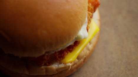 Placing-bun-on-a-fried-fish-sandwich-with-mayo-and-cheese