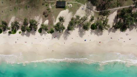 Lowering-overhead-vide-of-waves-crashing-onto-Oahu's-white-sand-beach