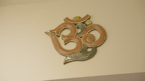 The-wall-is-decorated-with-an-art-piece-featuring-a-prominent-symbol-representing-yoga