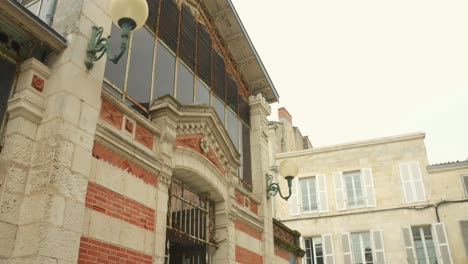 Tilt-down-shot-of-a-historic-food-market-called-Les-Halles,-La-Rochelle,-France-on-a-cloudy-day