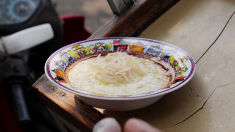 Street-vendor-preparing-Indonesian-porridge-with-shredded-chicken