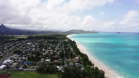 Aerial-view-of-Oahu's-shoreline-with-houses-going-all-the-way-up-to-the-coastline