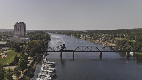 Augusta-Georgia-Aérea-V34-Paso-Elevado-Bajo-Que-Captura-El-Puente-Ferroviario-6th-St-Que-Cruza-El-Río-Savannah,-El-Parque-Riverwalk-Y-El-Paisaje-Urbano-Del-Centro-En-Un-Día-Soleado---Filmado-Con-Mavic-3-Pro-Cine---Octubre-De-2023