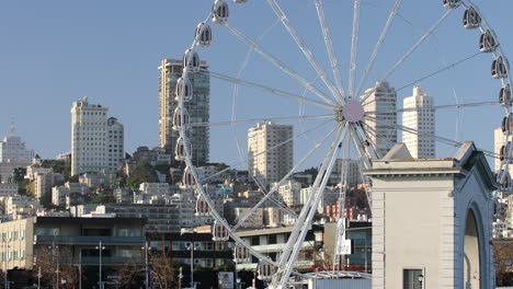 Ferris-Wheel-Known-as-Skystar-Wheel-with-City-Skyscrapers-and-Apartments-in-the-Background,-San-Francisco,-USA