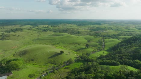 Lush-green-hills-and-fields-under-a-partly-cloudy-sky-in-florencia,-colombia,-aerial-view