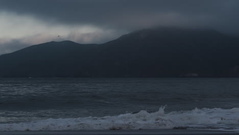 Bahía-De-San-Francisco-En-Un-Día-Nublado-Con-Suaves-Olas-Del-Océano-Y-Una-Vista-Lejana-De-La-Montaña