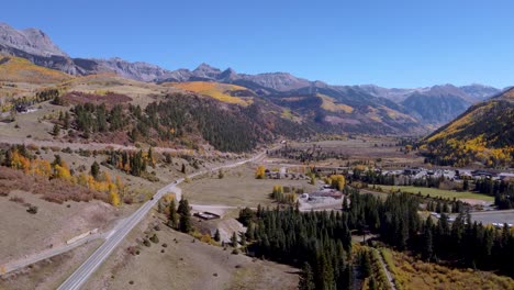 Aerial-view-of-the-Million-Dollar-Highway-running-toward-Silverton-Colorado-with-golden-aspens-lining-the-Rocky-Mountains-on-a-cloudless-day