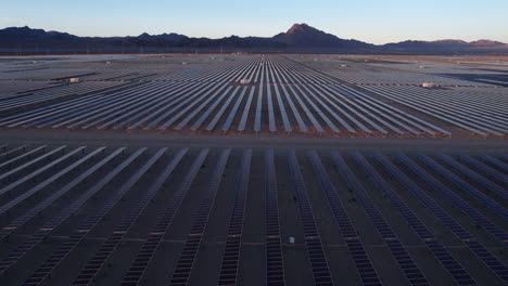 Solar-Power-Plant,-Aerial-View-of-Massive-Arrays-of-Solar-Panels-in-Desert-Landscape-at-Twilight,-Drone-Shot