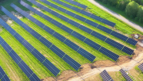 Aerial-View-of-Solar-Panels-on-Green-Field,-flyaway-shot-os-Solar-Farm