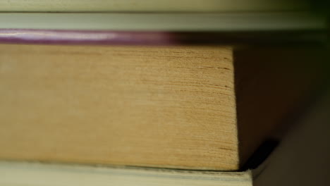 Macro-closeup-of-old-yellowing-book-pages-on-bookshelf-in-a-cozy-home