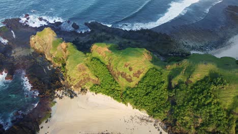 A-stunning-sea-cliff-surrounded-by-gentle-waves-with-crests,-break-softly-towards-the-shore-in-Merese-hills,-Mandalika-Lombok-Island