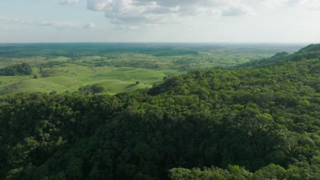 Lush-green-hills-and-valleys-under-a-blue-sky-in-Florencia,-Colombia,-aerial-view