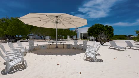Umbrella-canopy-over-white-sand-beach-provides-pleasant-shade-and-a-cozy-vibes,-Los-Roques
