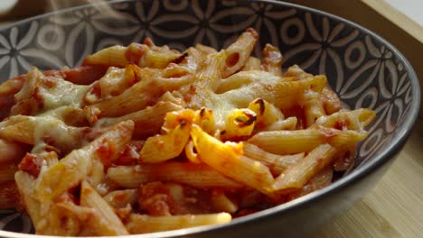 Primer-Plano-De-Pasta-Penne-Arrabiata-Picante-Con-Vapor-Subiendo-Con-Luz-Nocturna