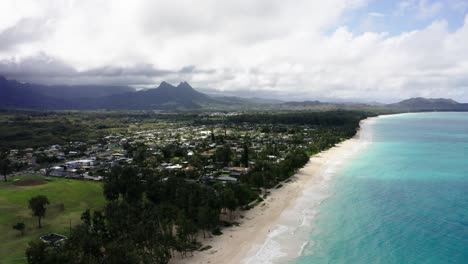 Drone-shot-of-Hawaii's-town-of-Waimānalo-at-midday,-teal-water