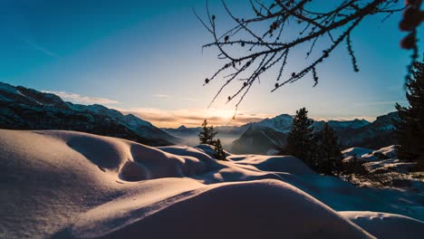 Sunset-time-lapse-over-snowy-mountain-Alps-vista,-eerie-winter-scene-at-twilight