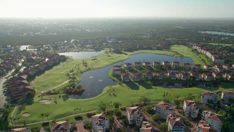 Drone-shot-of-the-sunrise-hitting-the-green-grass-on-a-golf-course-in-Florida